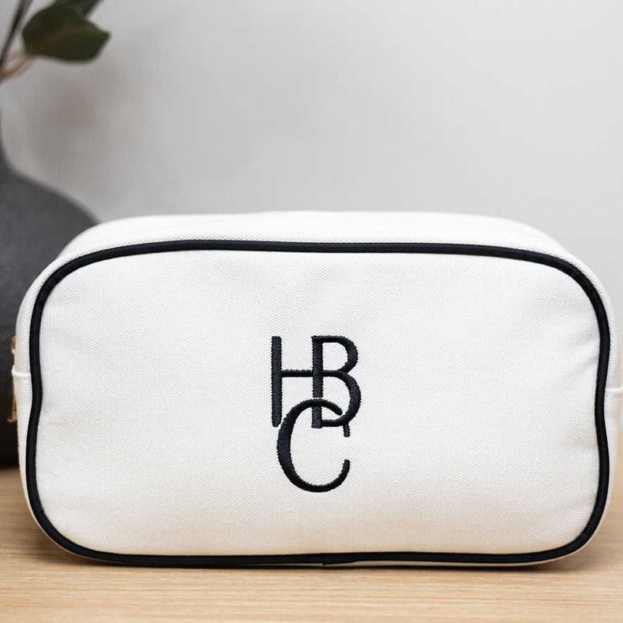 'HBC' White canvas bag with black border.