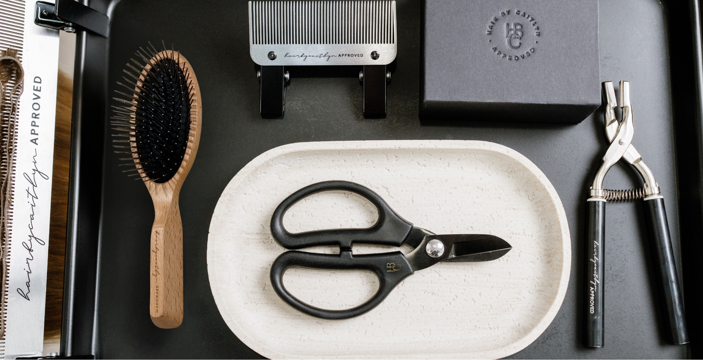 Custom hair extension tools created for efficiency on a black tray.
